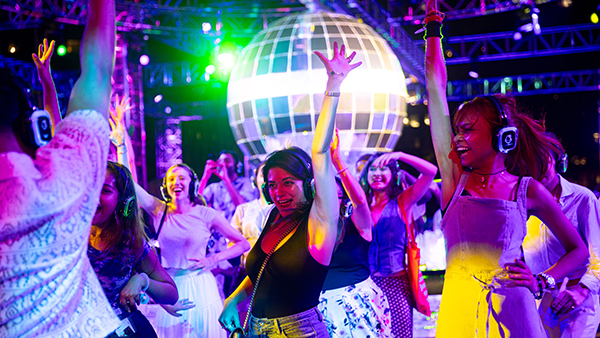 People dance wearing headphones under the disco ball