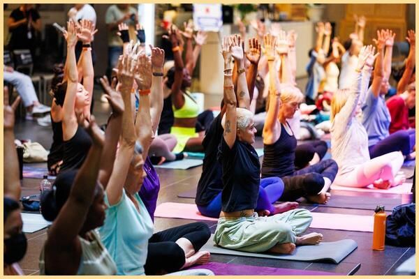People sit on yoga mats on the floor