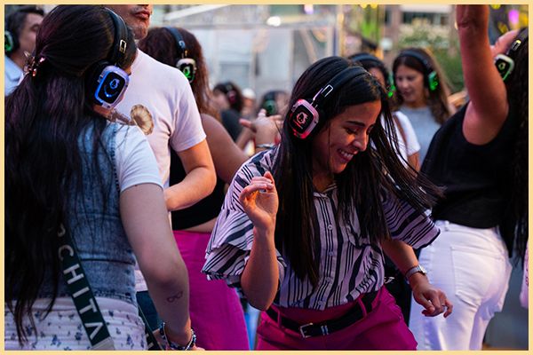 Women wear headphones and dance