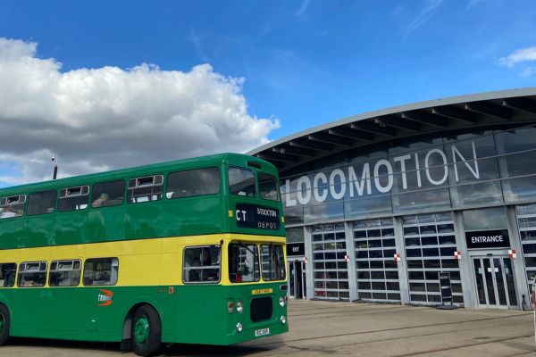 A green and yellow bus outside Locomotion