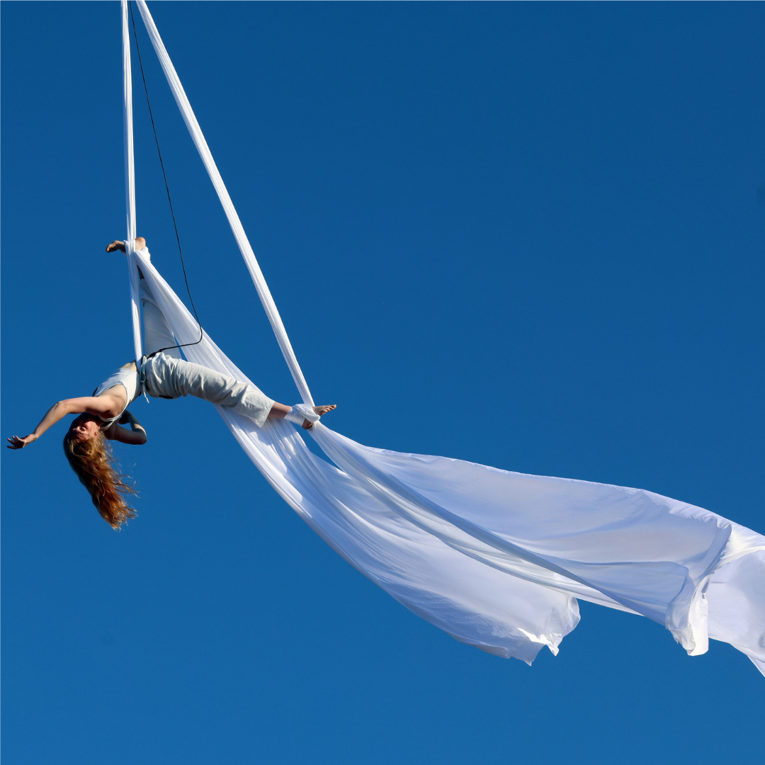 An aerial performer against blue sky