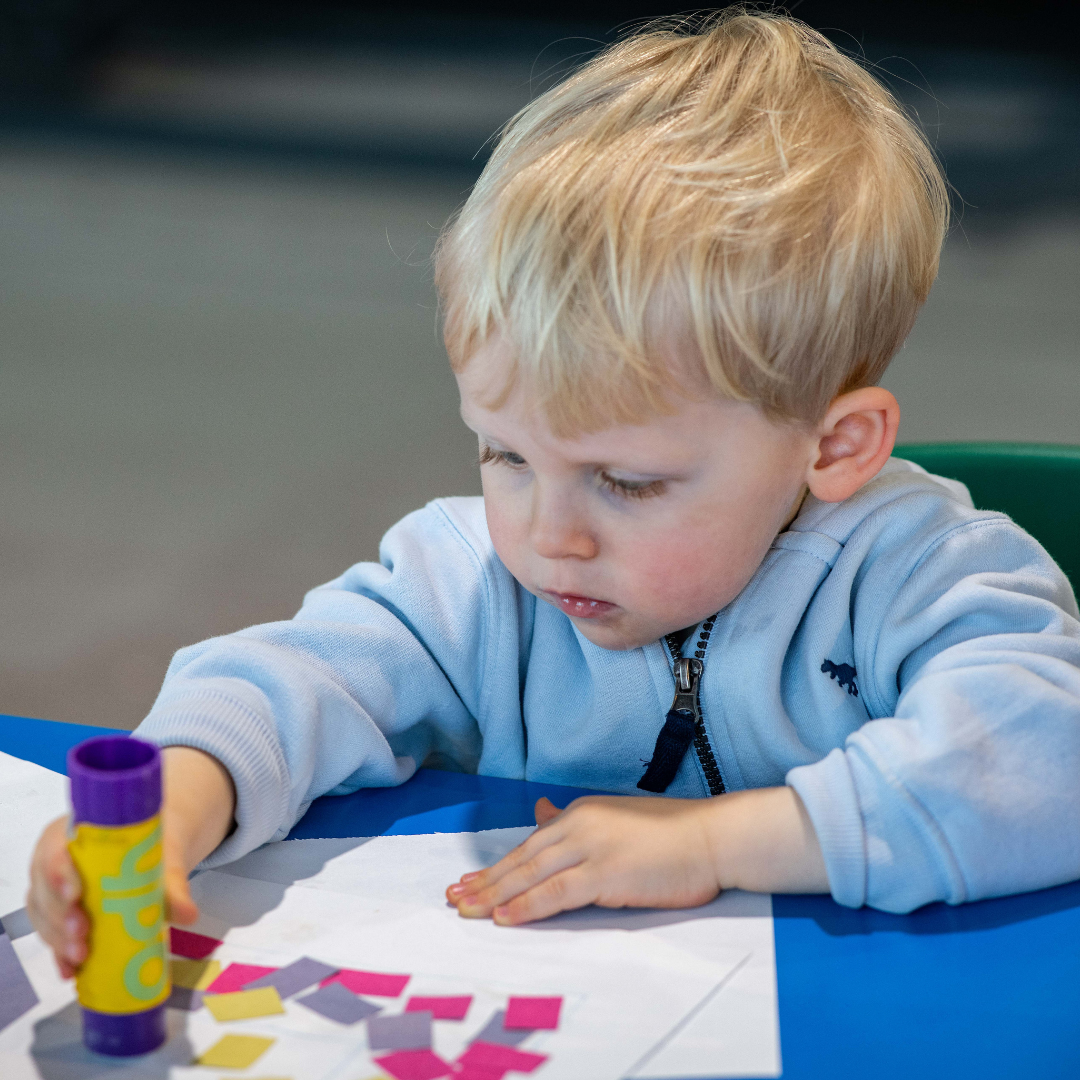 A young boy using glue for craft activities