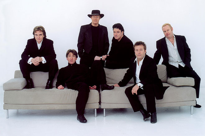 Image of The Hollies sitting on a couch