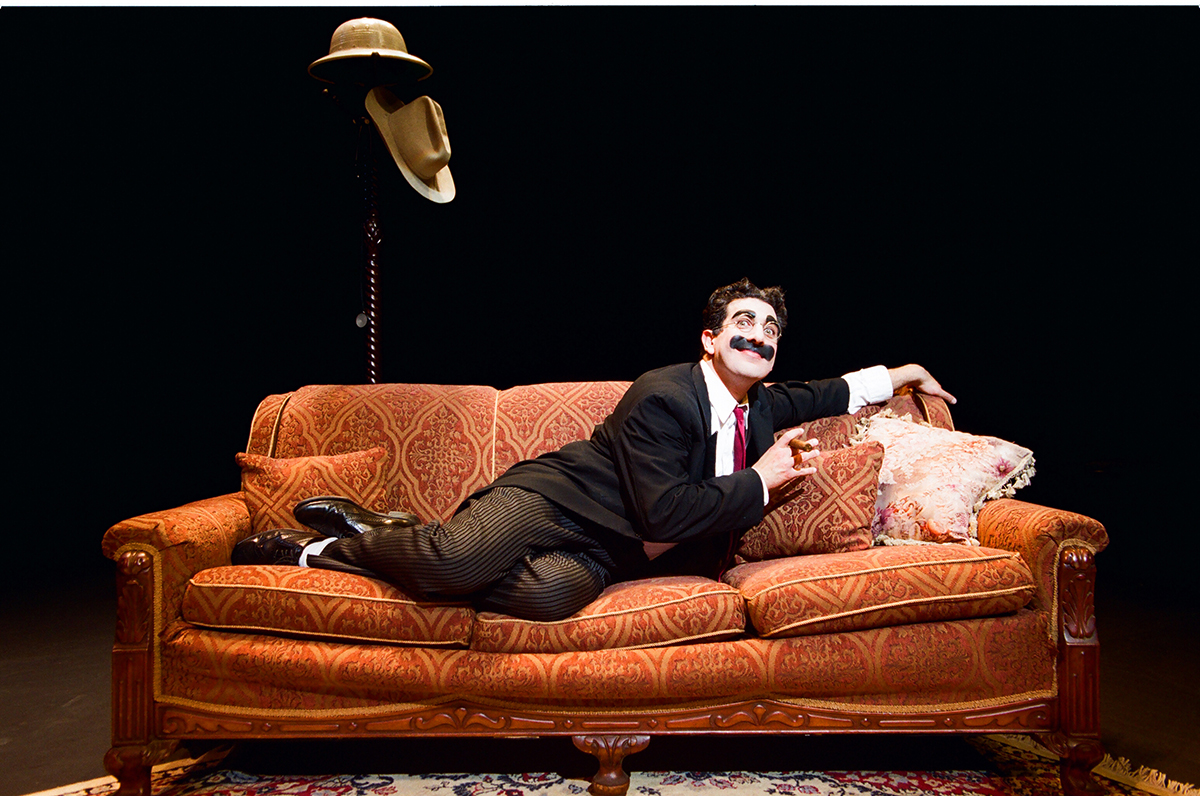 Image of Frank Ferrante as Groucho Marx lying on couch