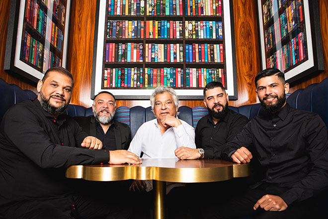 Gipsy Kings band members seated around table