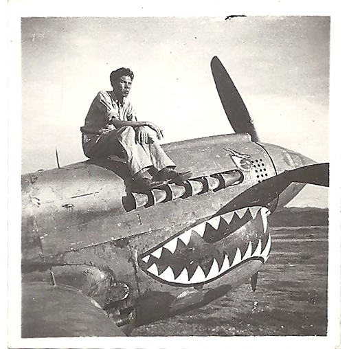 A black and white photo of a man sitting on top of a propeller plane