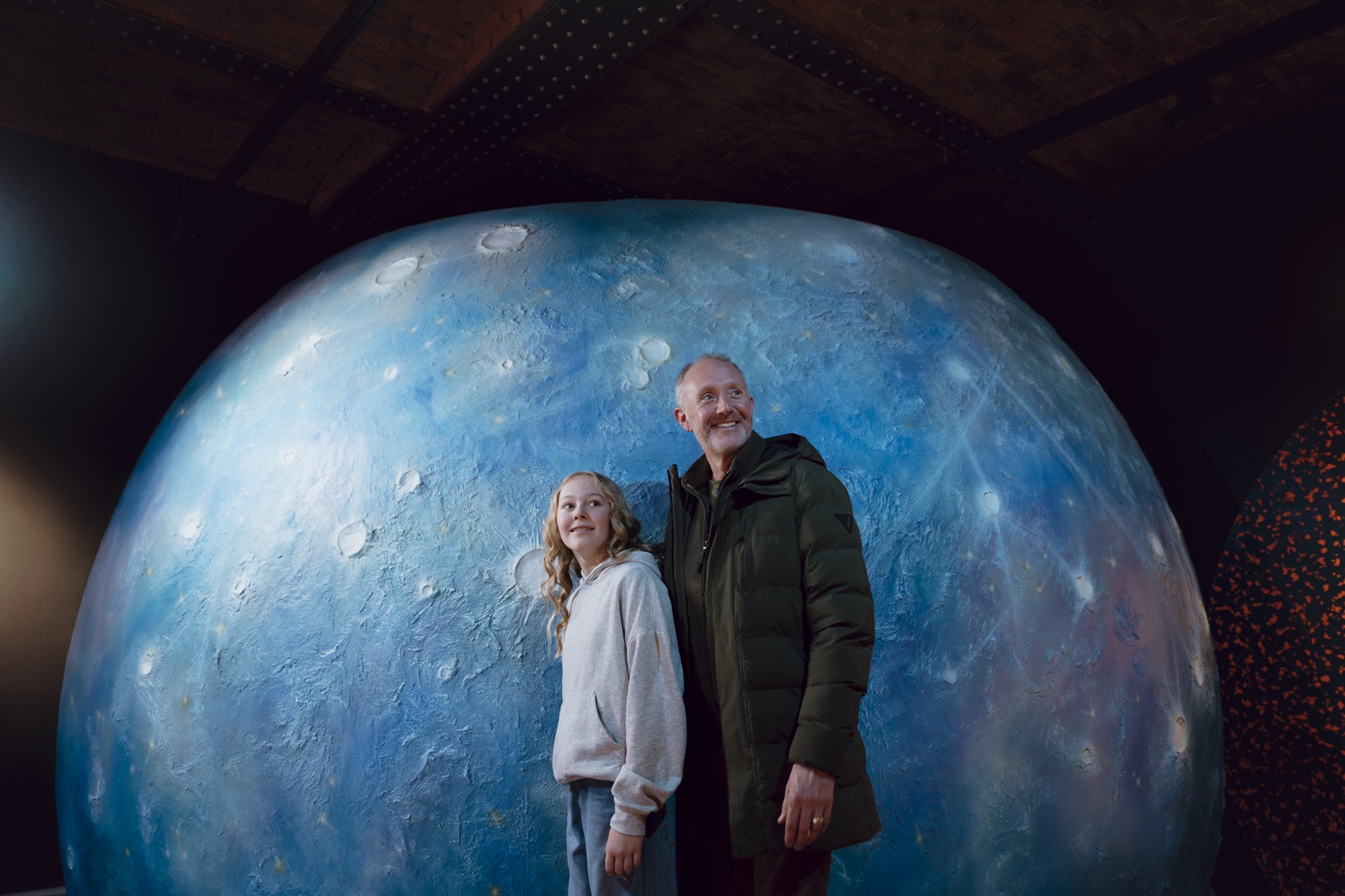 Dad and daughter stood in front of Mercury display in Horrible Science: Cosmic Chaos