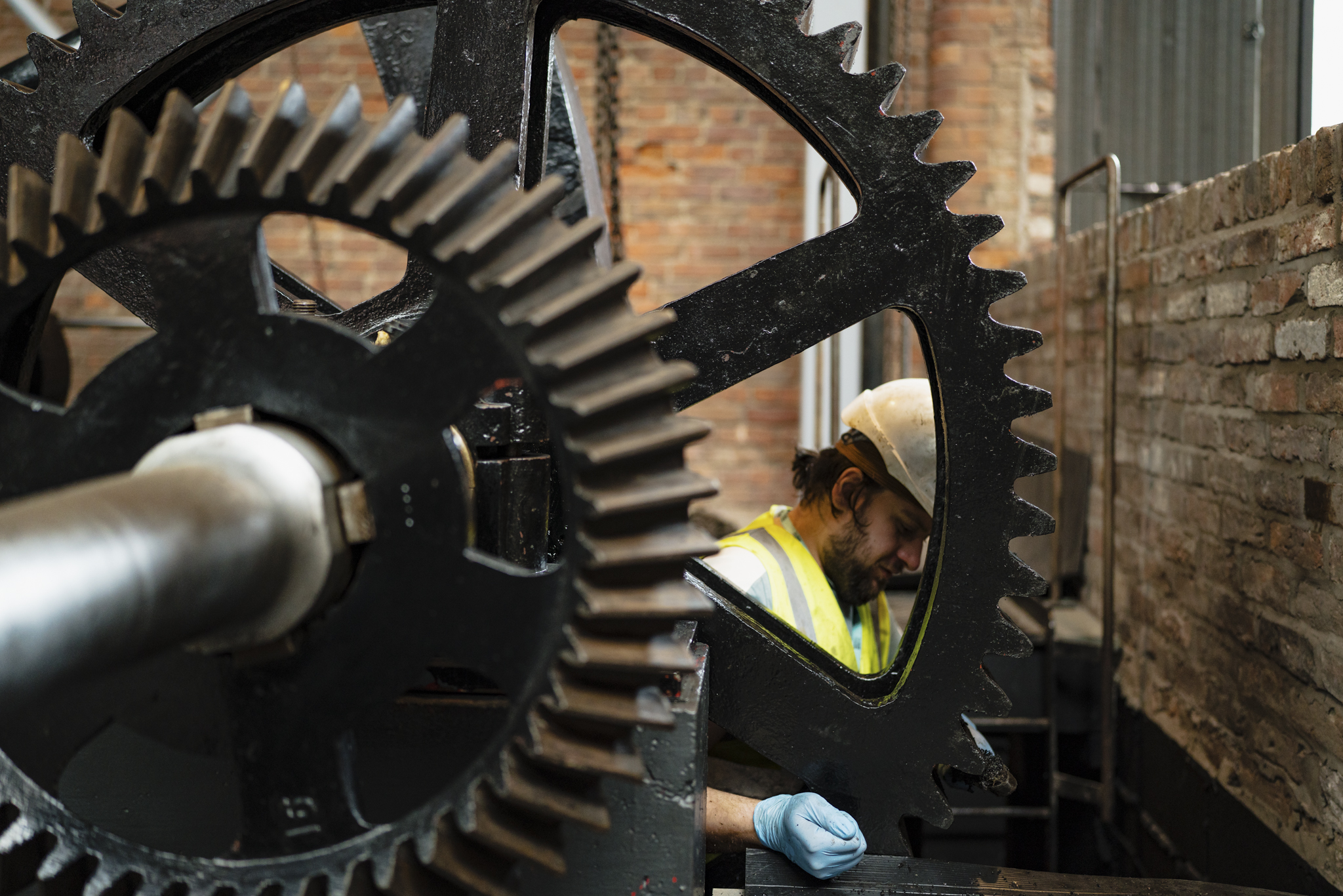 Museum technician cleaning a large engine in Power Hall