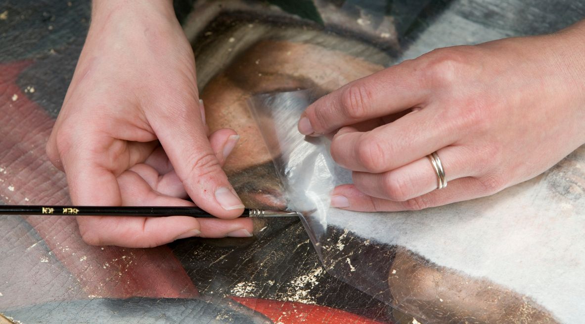 Conservator peeling back melinex, 2019 © The National Gallery