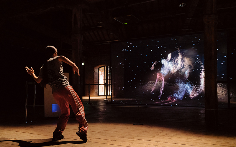A girl dances and interacts with the exhibit.