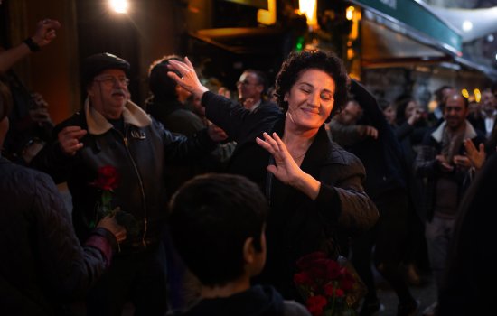 A woman dances in a crowd as people around here clap