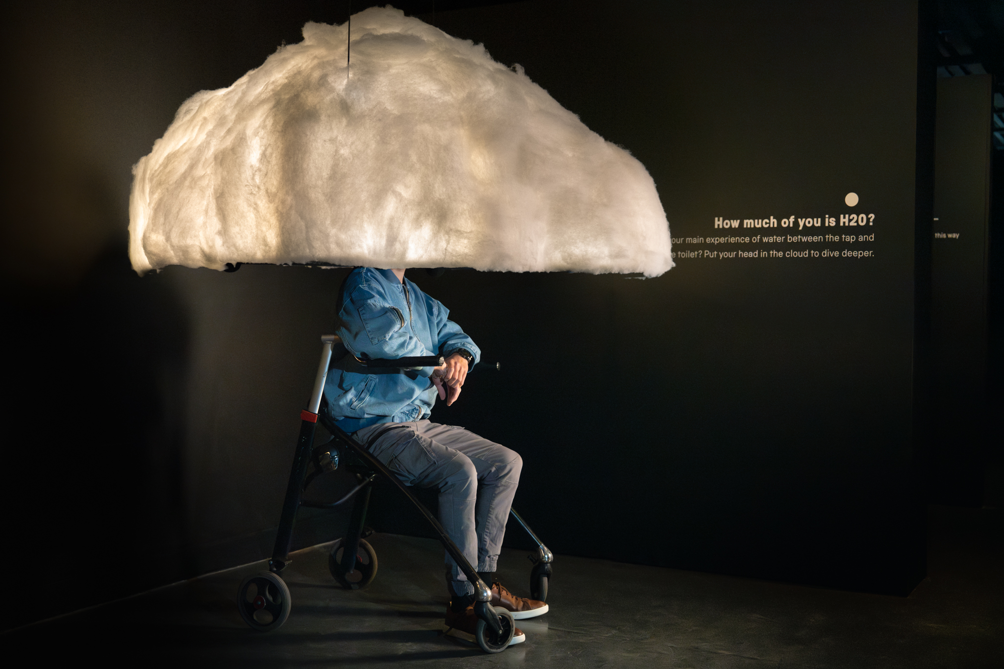 A person sitting in a walker with their head in a cloud interactive in YOU:MATTER