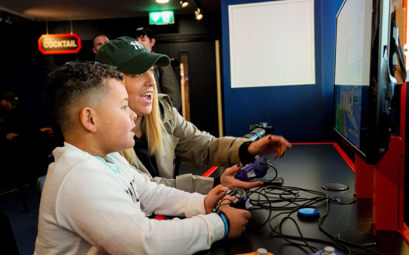 A woman and a child playing a videogame in Power Up