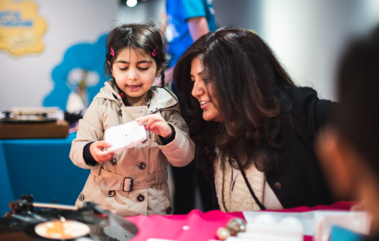 A young girl and her mum doing an activity at the national science and media museum