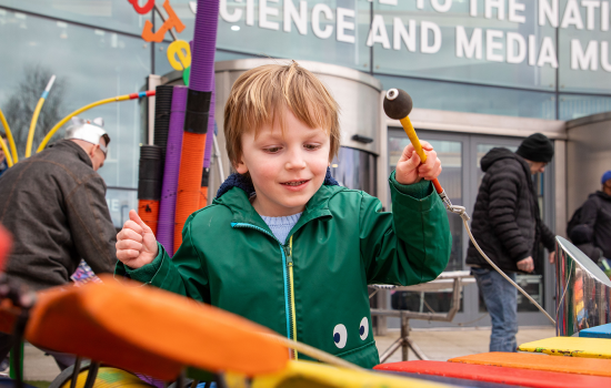 A child playing a colourful xylophone