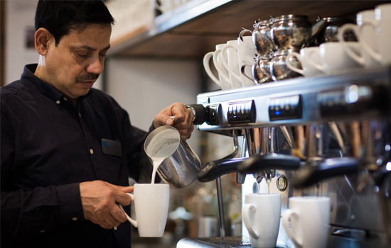 A man serving coffee in a café