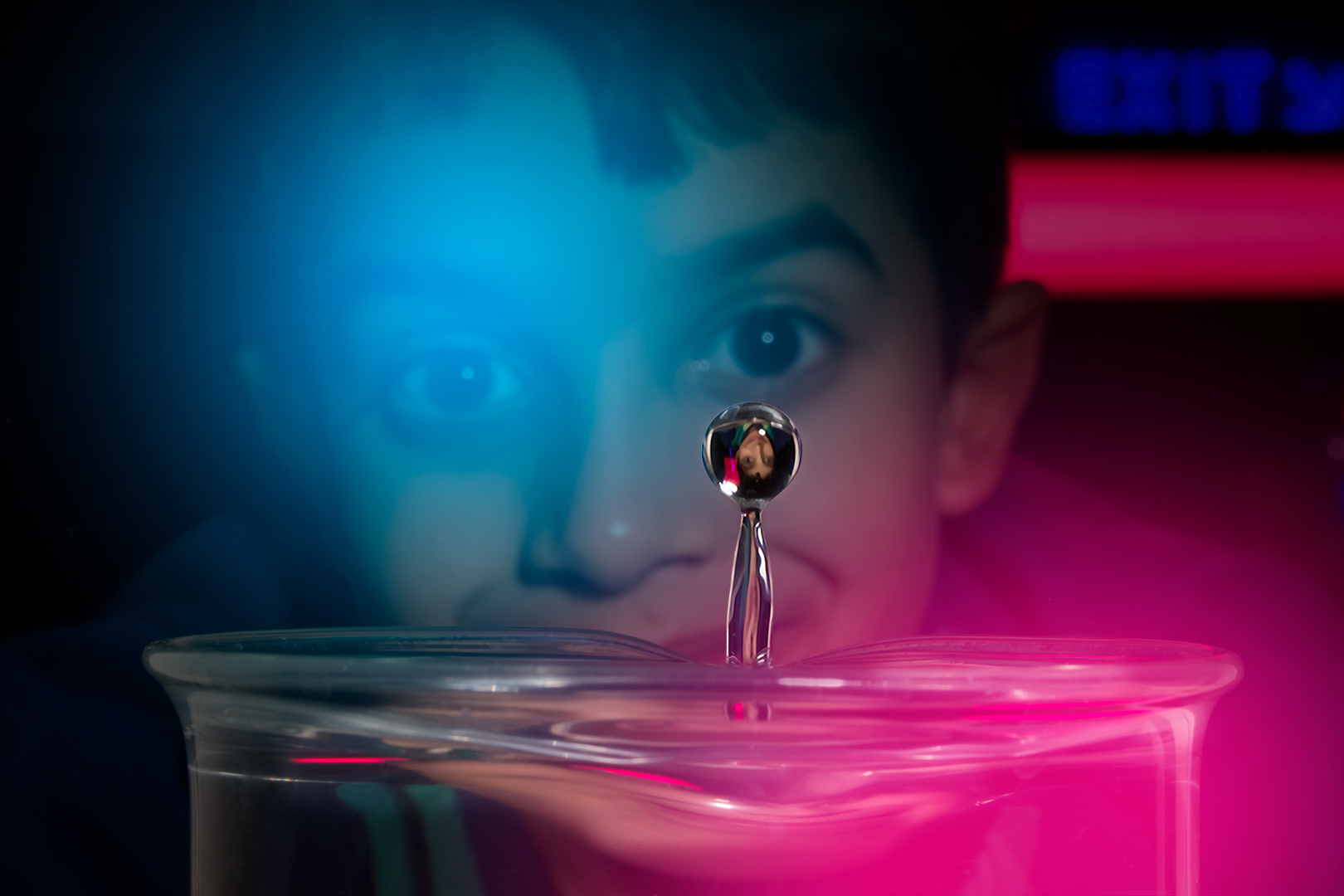 A young boy looking at a water droplet in Wonderlab.