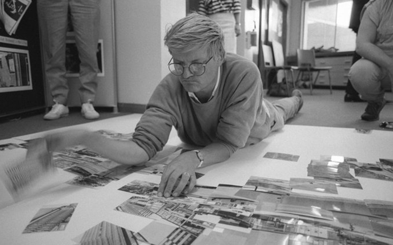 David Hockney lying on the floor surrounded by photographs