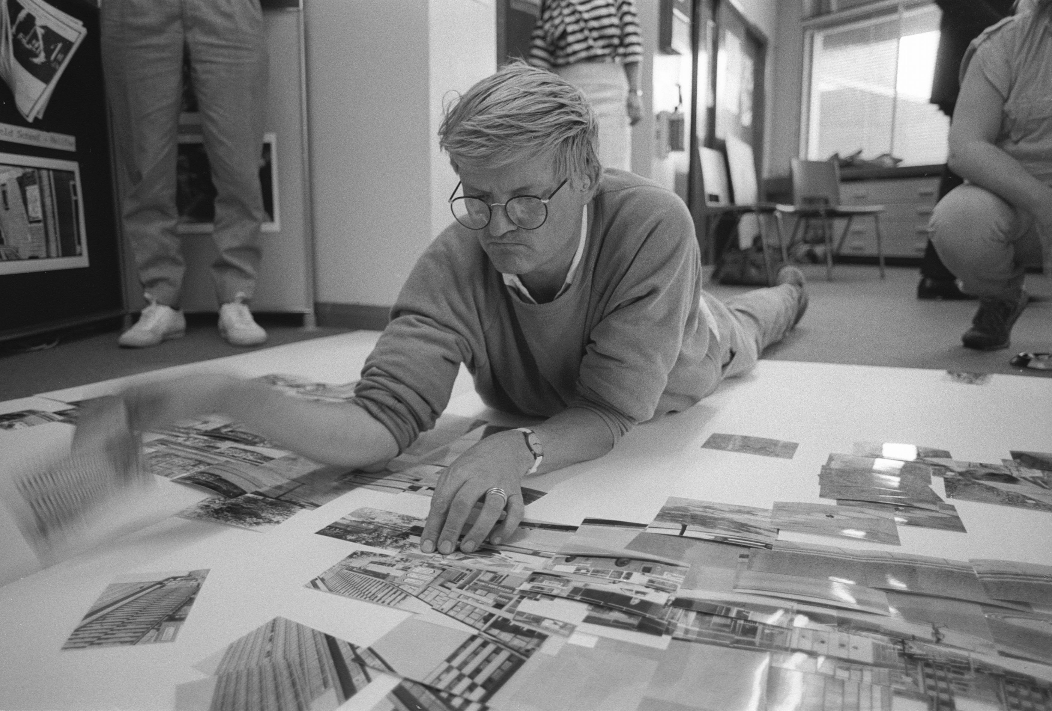 Artist David Hockney lies on the floor arranging photographs for one of his joiners collages