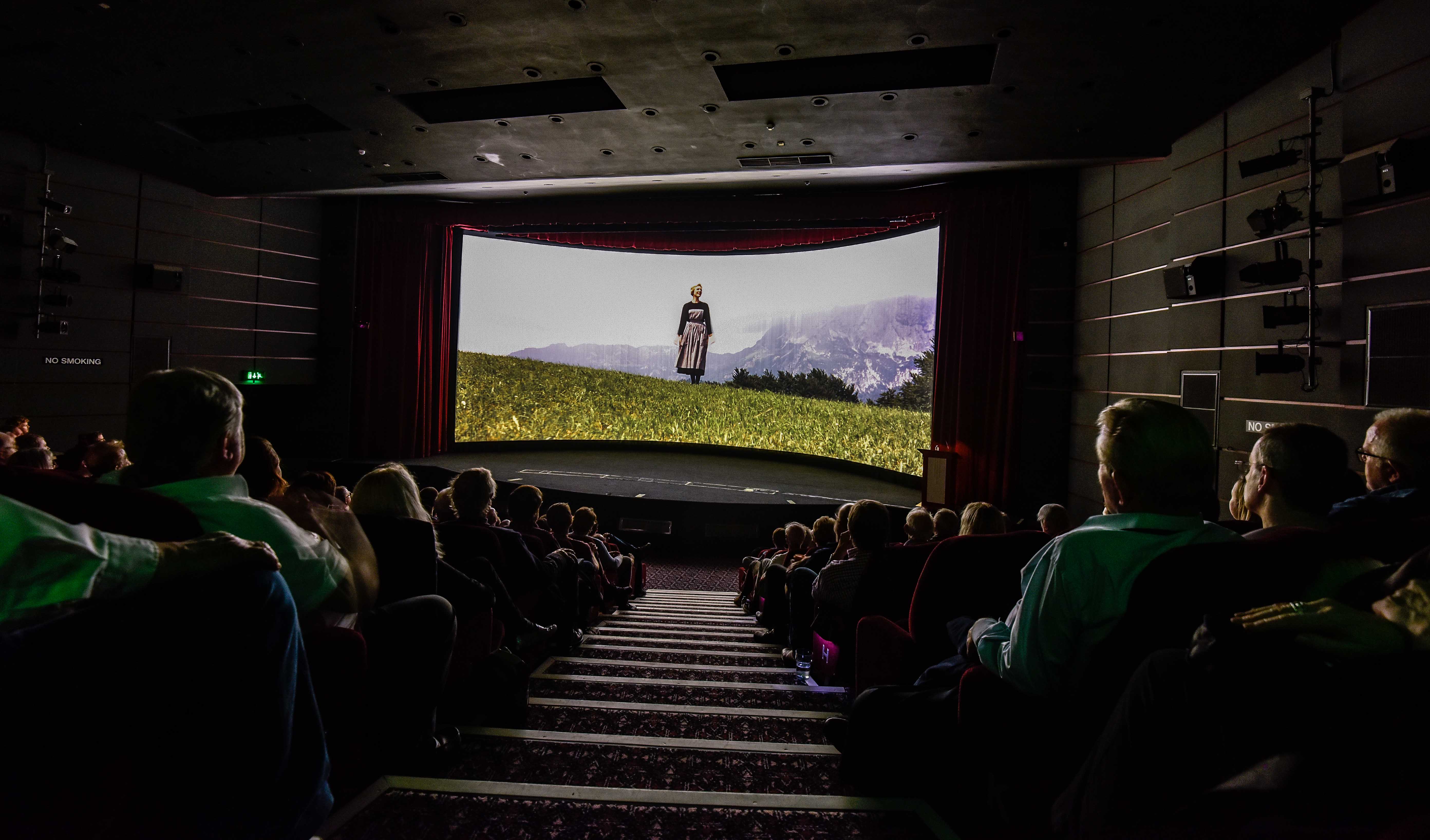 A curved cinema screen with a still from The Sound of Music
