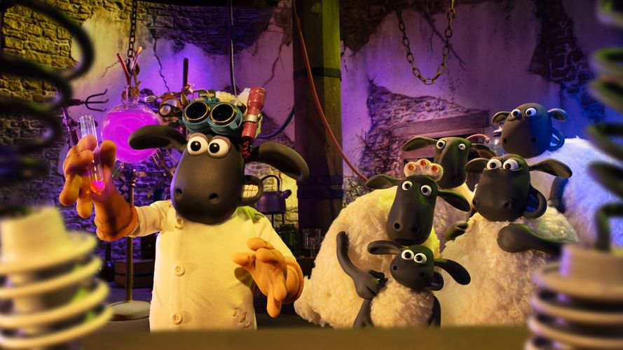 Shaun the Sheep wearing a lab coat and holding a test tube while other sheep stand behind him looking worried