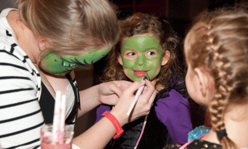 A children having their face painted green