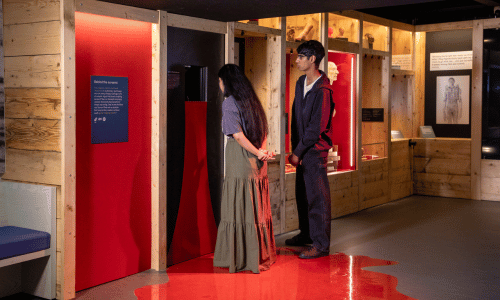 Two people standing in the vinyl pool of blood in Sound and Vision