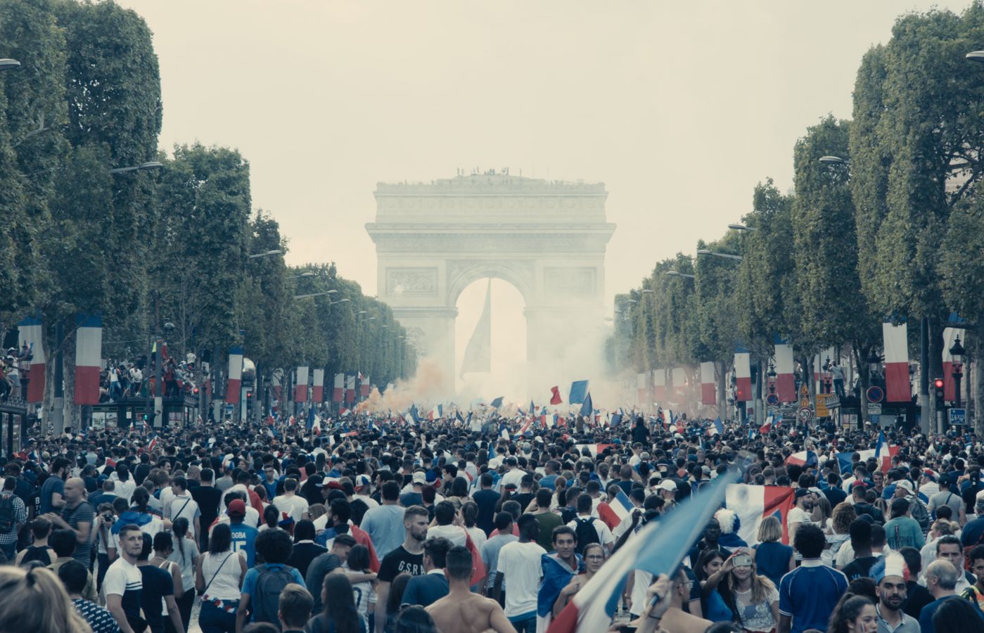 Still from Les Miserables featuring a crowd leading up to the Arc de Triomphe