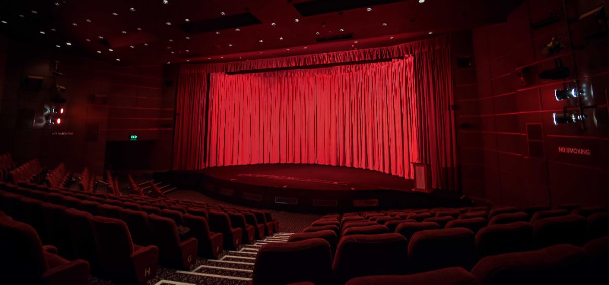 Pictureville Cinema auditorium, with the curved screen covered by iconic red curtains.