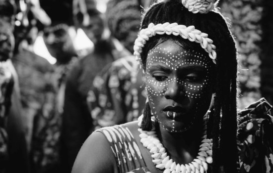 A Nigerian woman stares off camera in a striking black and white image.