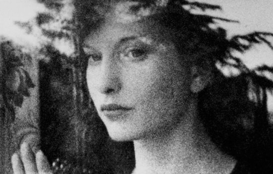 A black and white image of a woman staring out a window.