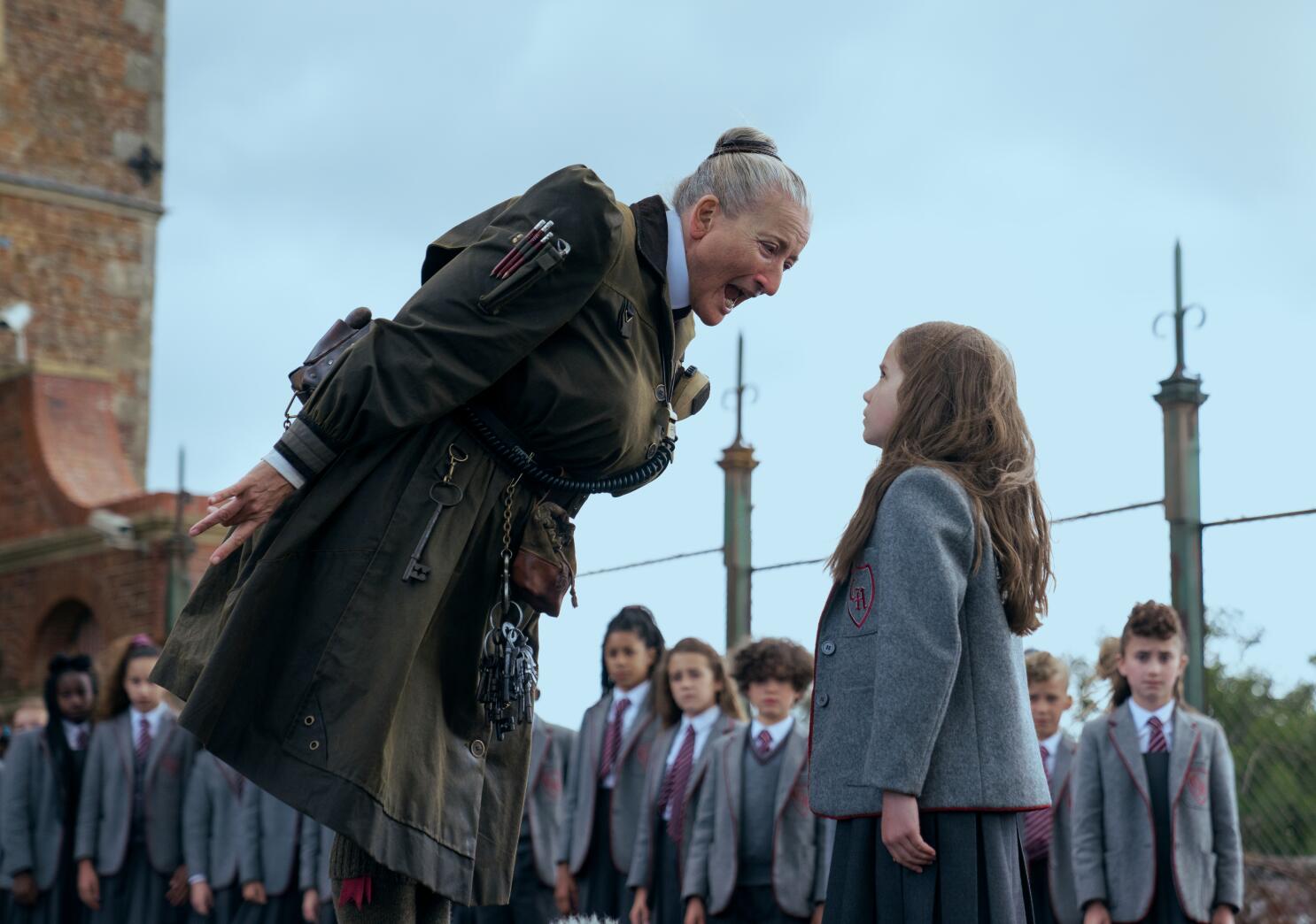 A still from Matilda The Musical of Mrs. Trunchbull towering over Matilda