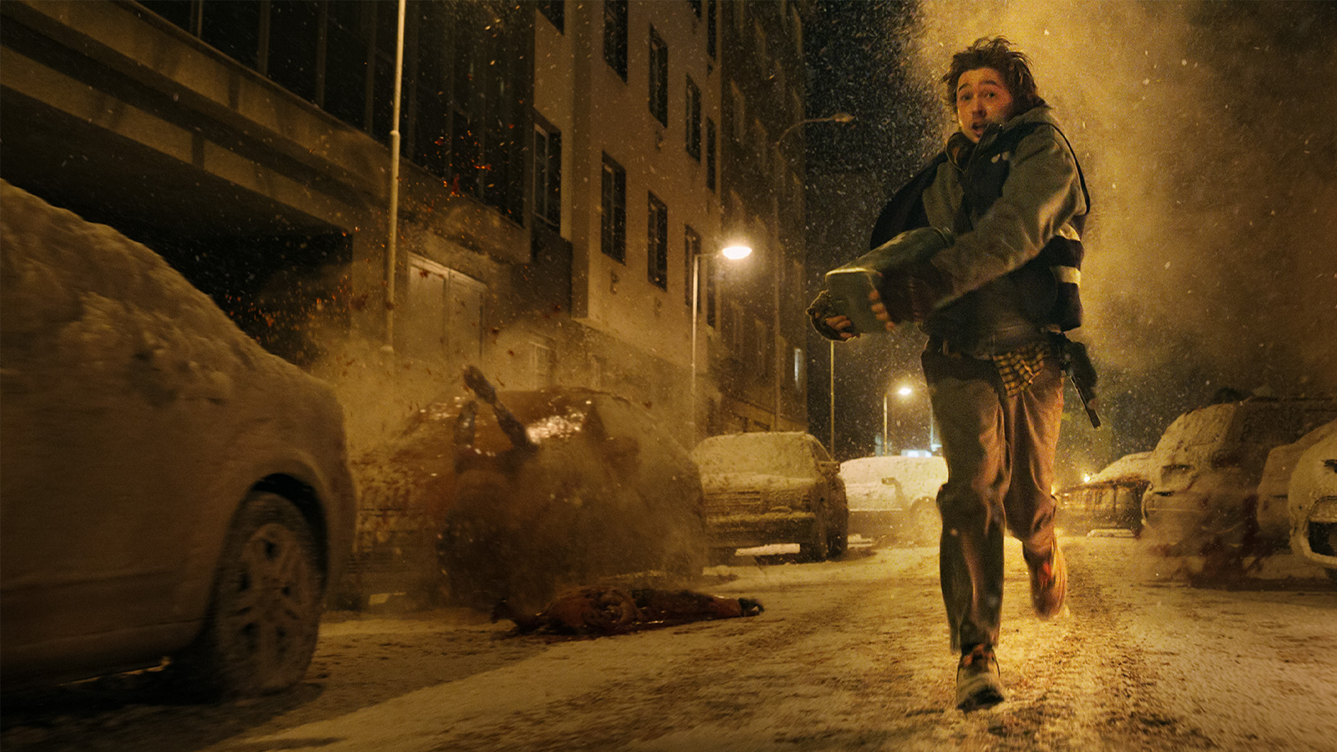 A young man runs through a street full of debris and rubble
