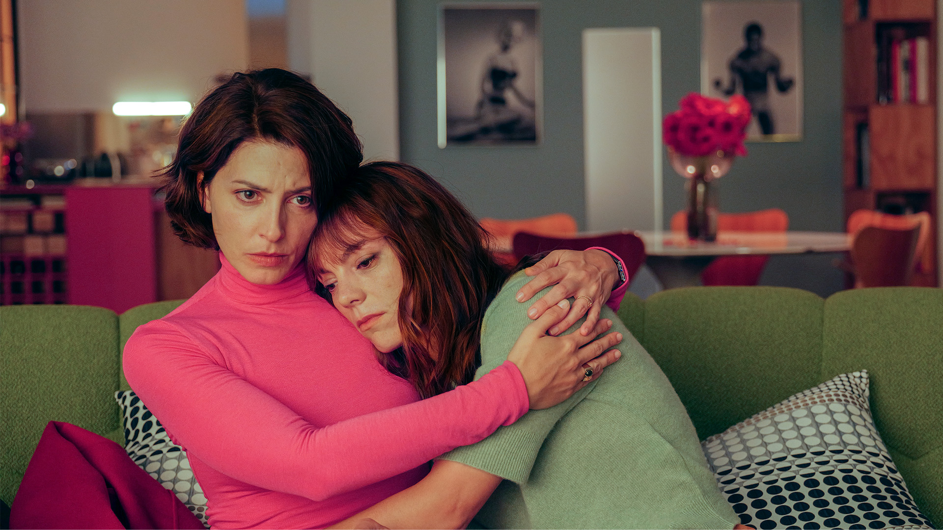 Two women embrace on a sofa