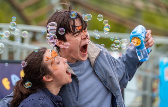 A still from Sunny Dancer, featuring two young adults playing with a bubble machine.