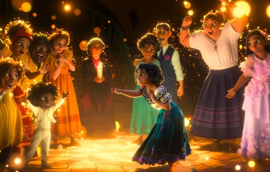 A still from Encanto of a young girl surrounded by her family and twinkling lights surround her.