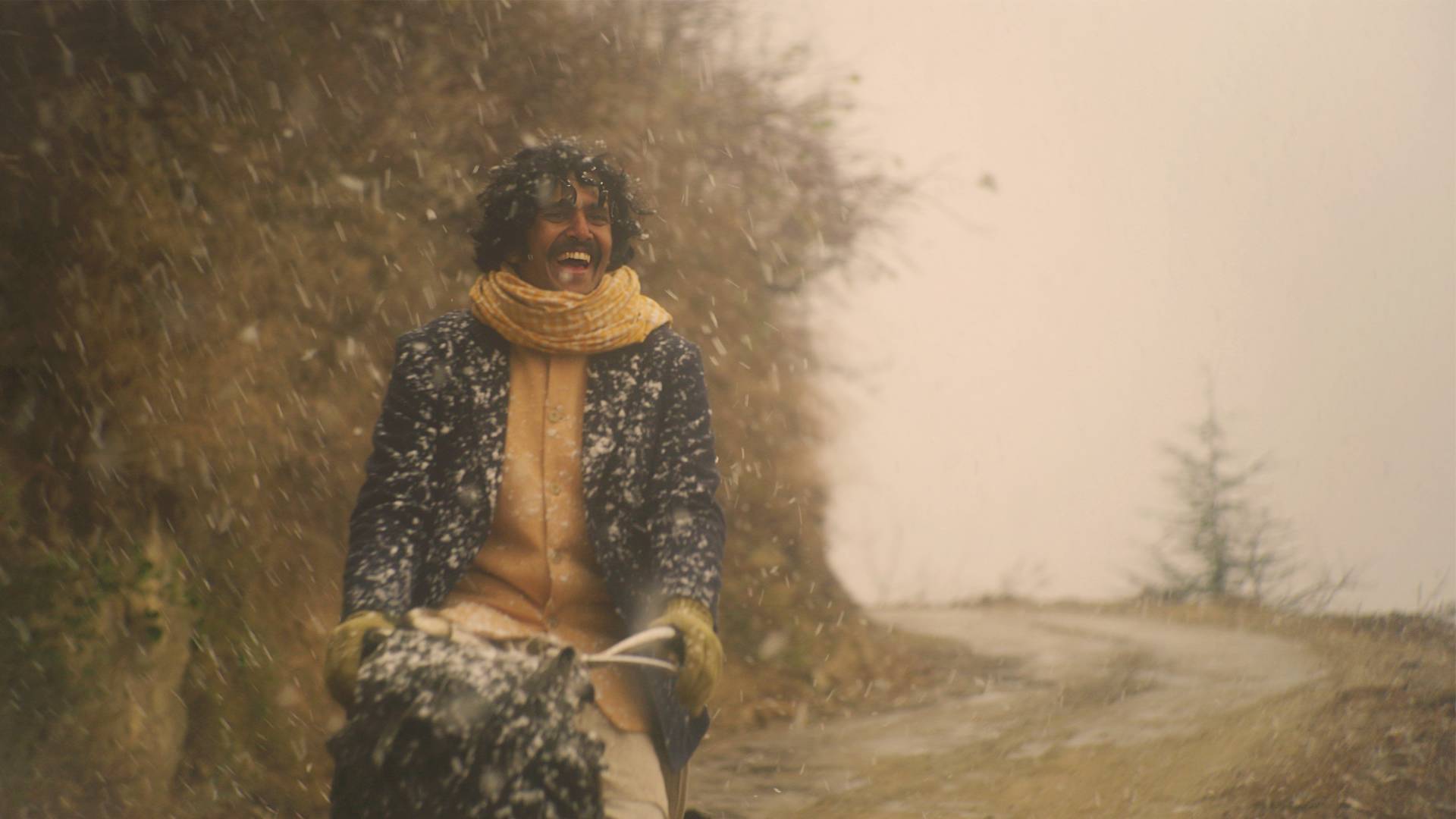 A smiling man rides a bike