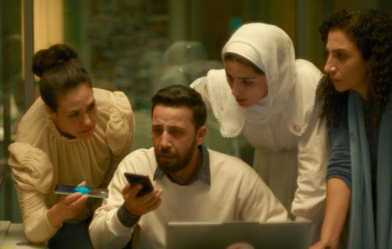 A group huddle around a phone