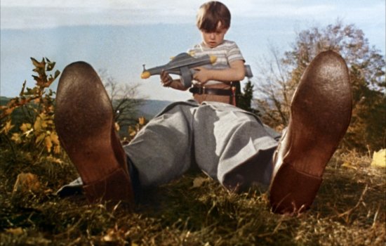 A young boy stands over a body