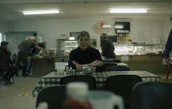 A woman sits at a cafe table.