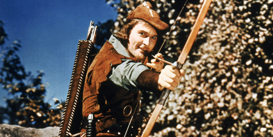 Erroll Flynn is dressed as Robin Hood, aiming an arrow at something off screen.