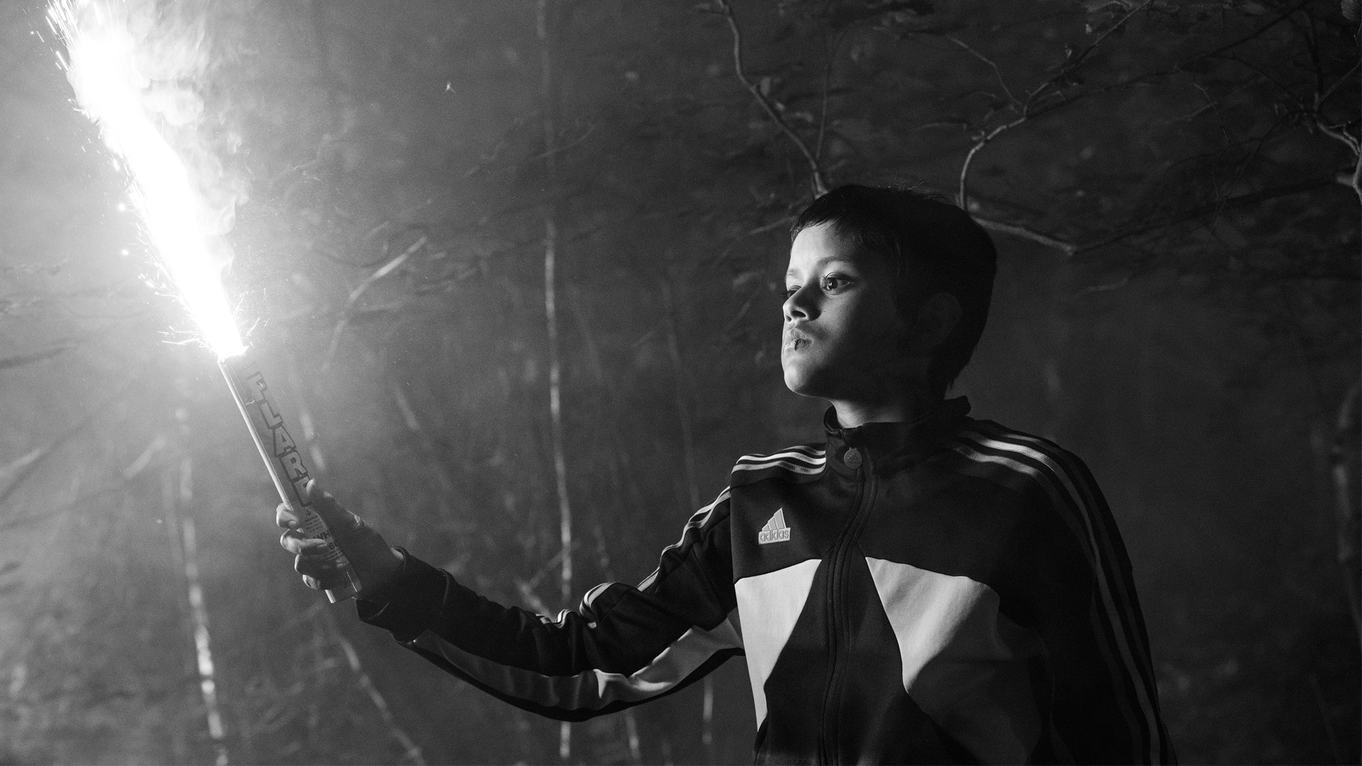 A young boy holds a flare.