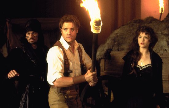 A still from The Mummy of Brendan Fraser holding a flaming torch, exploring an archaeological site.