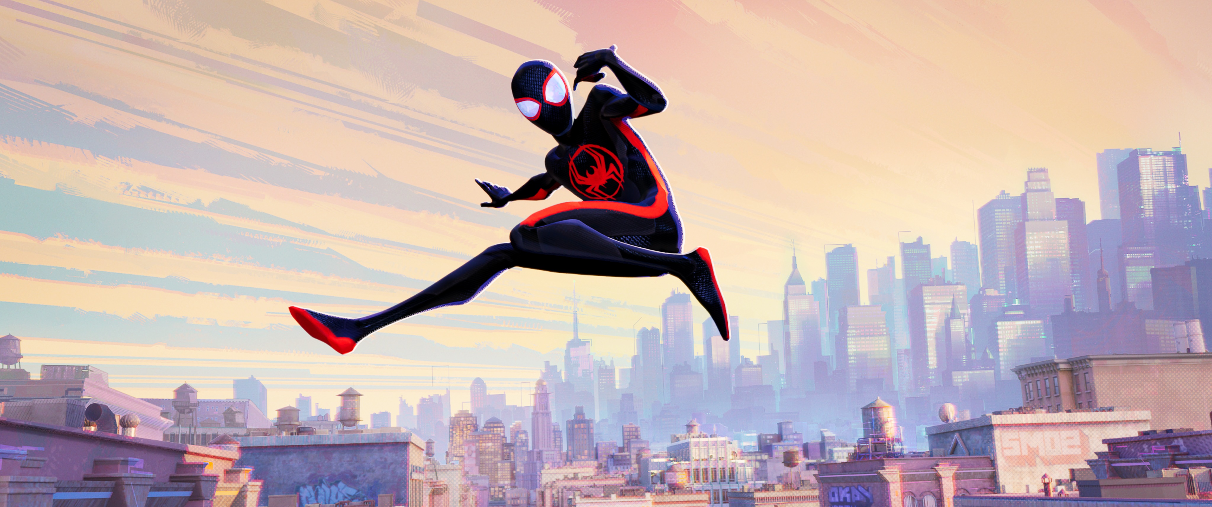 A still from Spider-Man: Across the Spider-Verse featuring Miles Morales leaping midair with the New York skyline in the background.