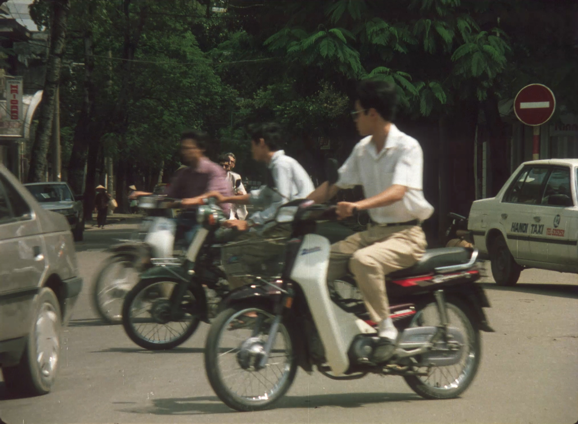 A Vietnamese road featuring multiple motorbikes mid-motion.