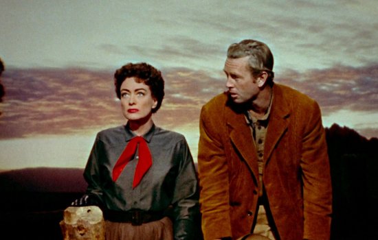 Joan Crawford and Sterling Hayden stand side by side.