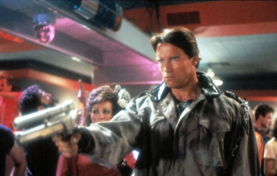 An image of Arnold Schwarzenegger holding a futuristic gun in the middle of a busy dancefloor with a cold expression on his face.