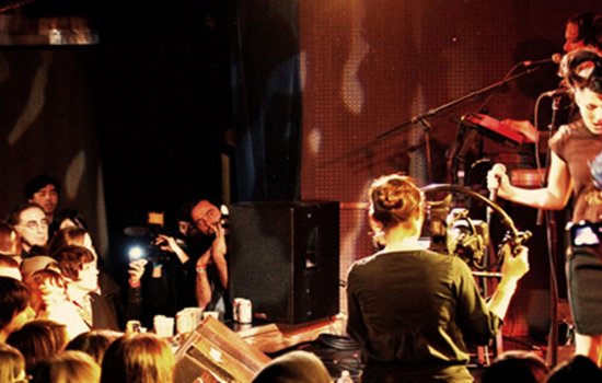 Kathleen Hanna dances on stage mid-performance.