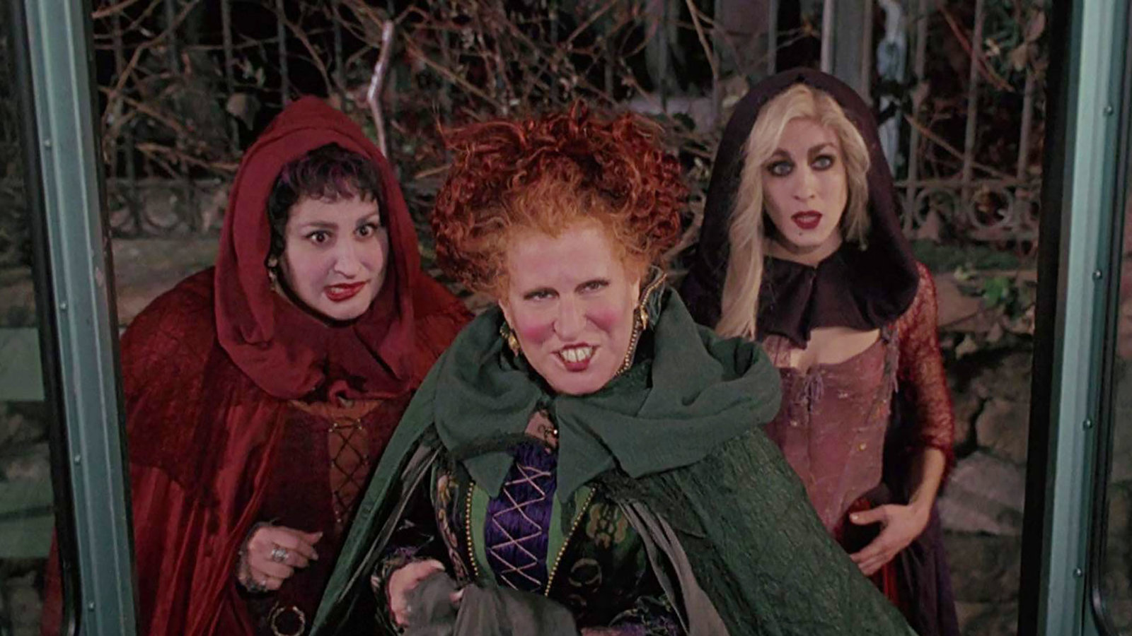 Three witches stand side by side glaring at someone offscreen.