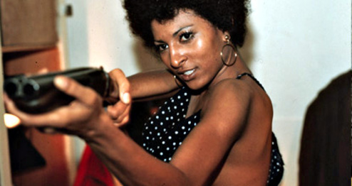 Pam Grier holds a gun.